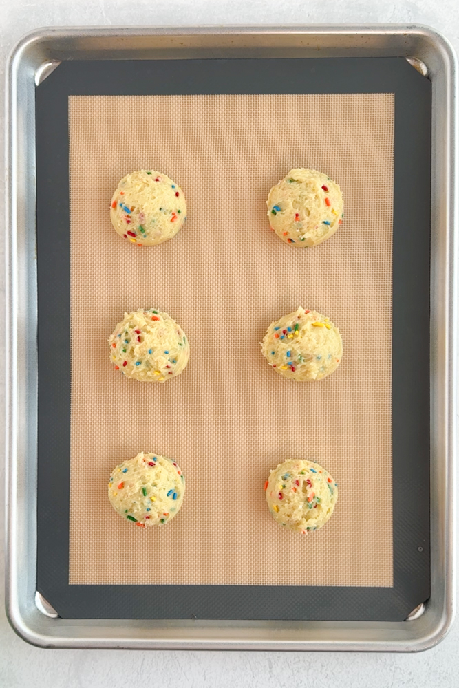 Scooped cookie dough on a baking sheet pan.