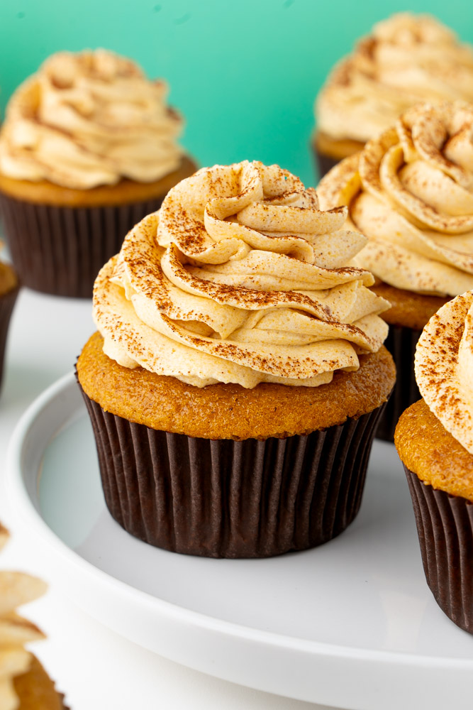 Double pumpkin spice cupcakes on a white plate.