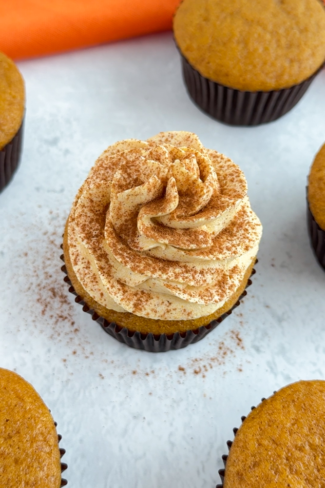 Pumpkin spice cupcakes with frosting and cinnamon.