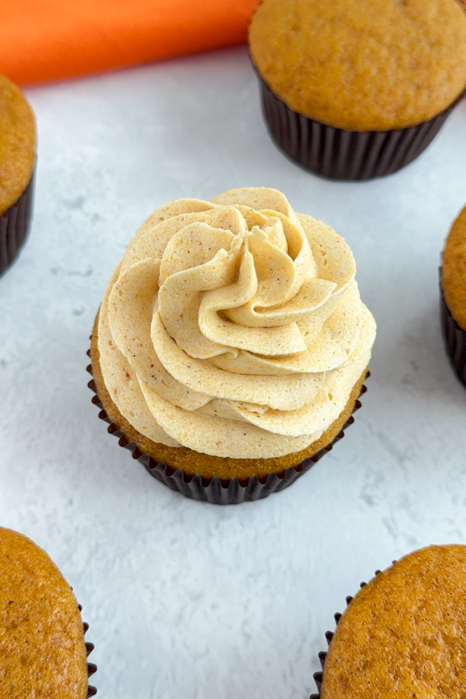 Pumpkin cupcakes frosted with pumpkin frosting.