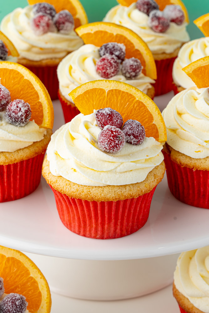 Cranberry orange cupcakes on a cake stand.