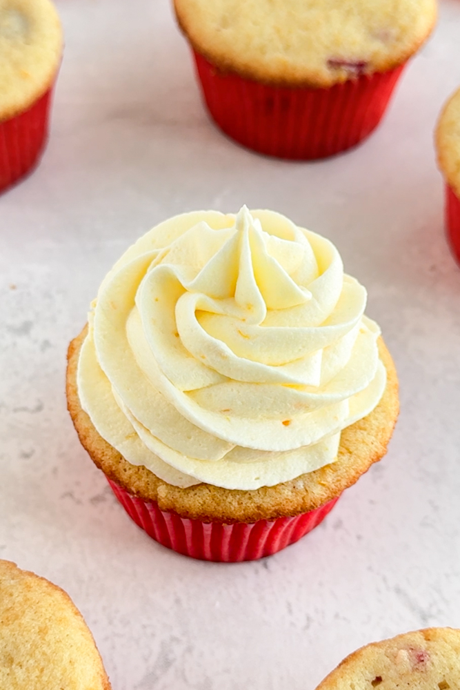Cupcakes frosted with orange cream cheese frosting.