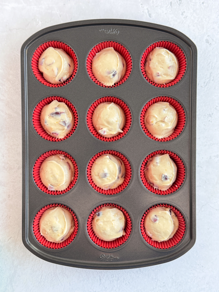 Cupcake batter divided into cupcake liners in a cupcake pan.