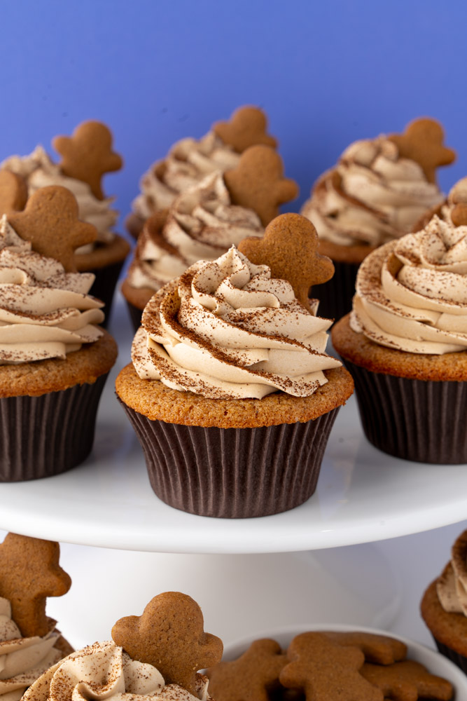 Gingerbread latte cupcakes on a white cake stand.