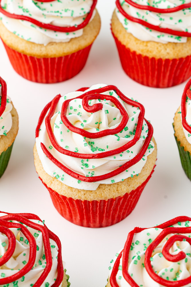 Little Debbie Christmas tree cupcakes made with vanilla cupcakes with vanilla frosting, red stripes, and green sanding sugar.