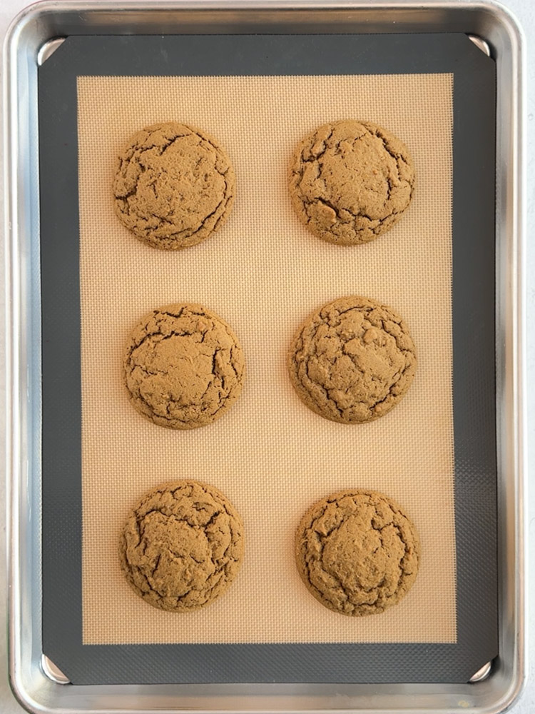 Baked gingerbread cookies on a baking sheet pan.