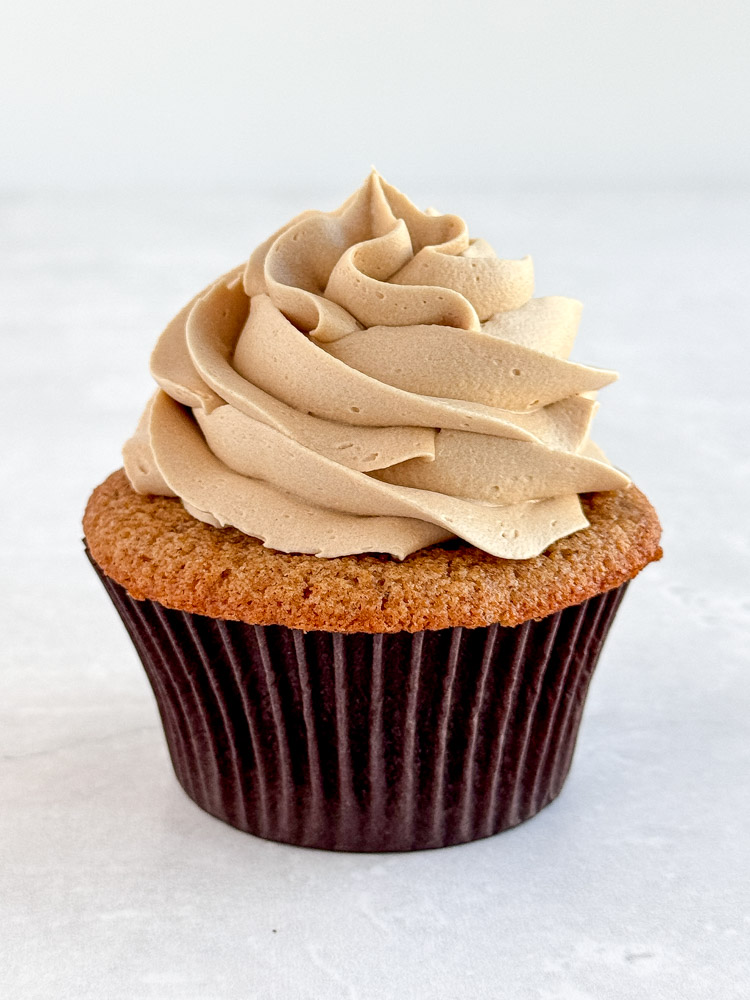 A gingerbread cupcake frosted with coffee buttercream frosting.