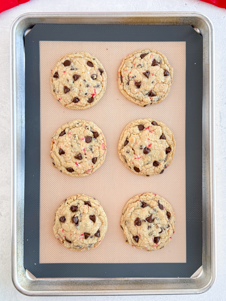 Baked peppermint chocolate chip cookies on a baking pan.
