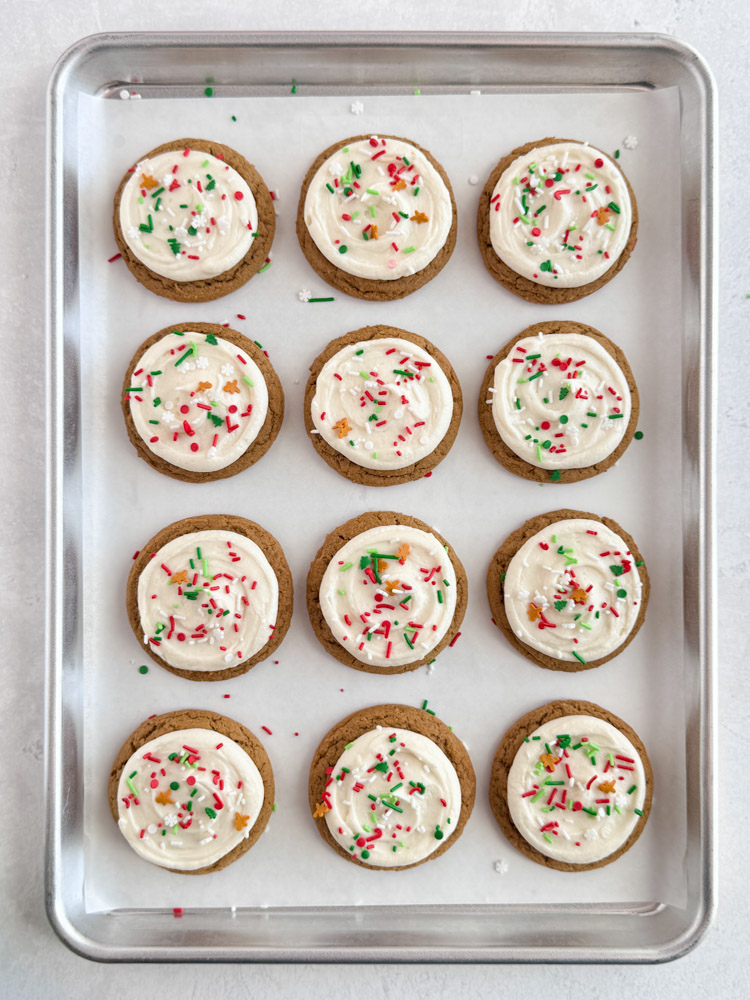 Gingerbread cookies iced with cream cheese frosting and decorated with sprinkles.