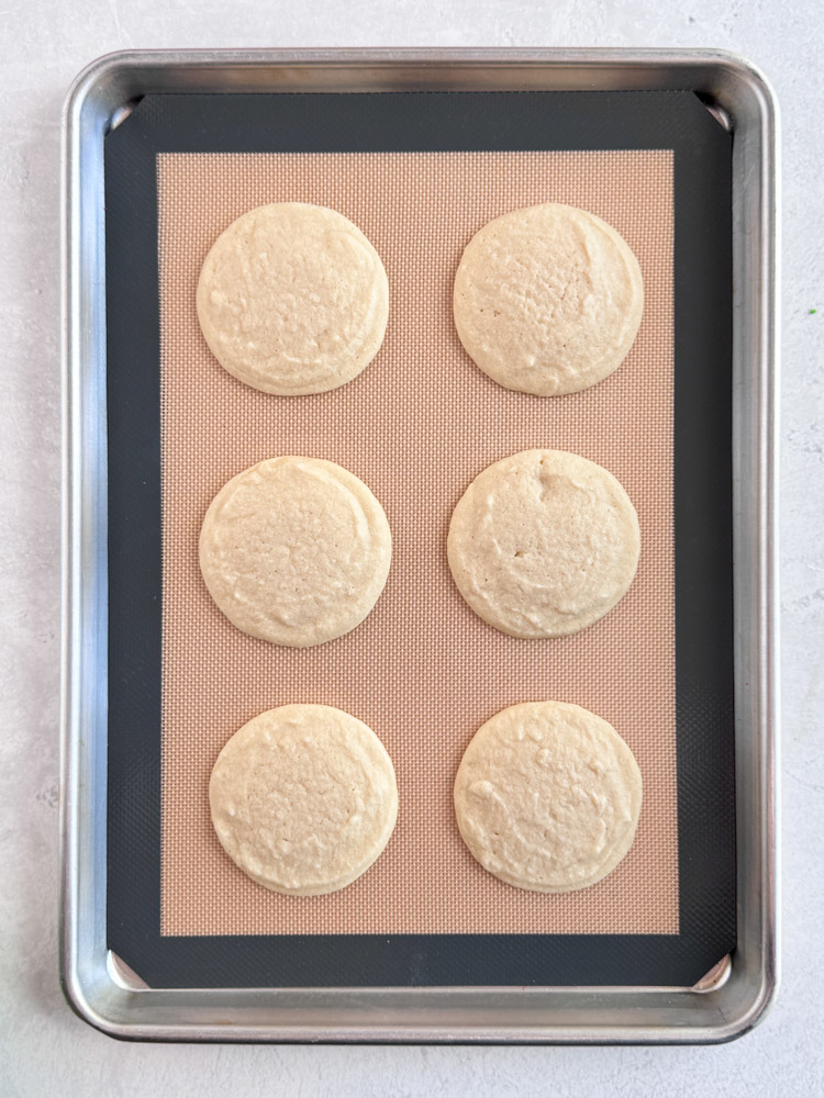 Baked vanilla cookies on a baking sheet pan.