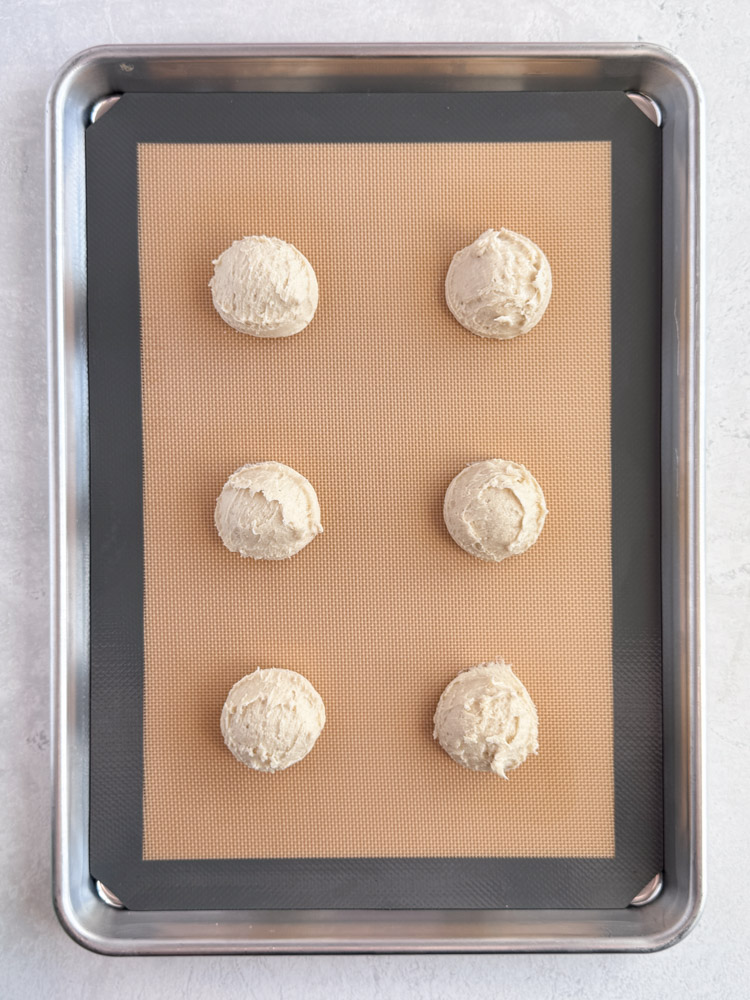 Vanilla cookie dough balls on a baking sheet pan.