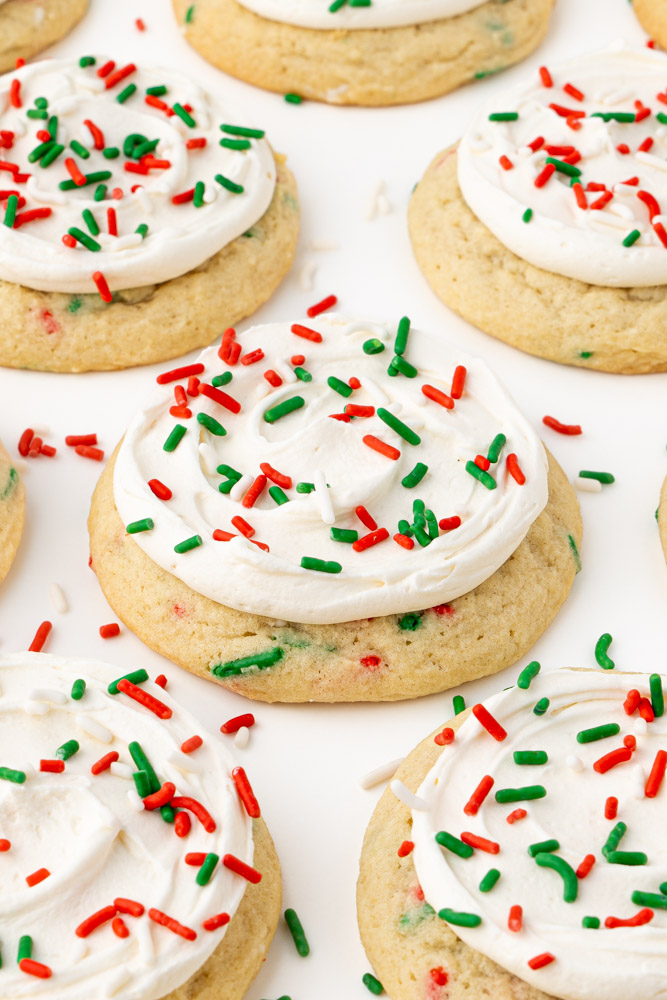 Soft and chewy vanilla sugar cookies with vanilla frosting and holiday sprinkles.