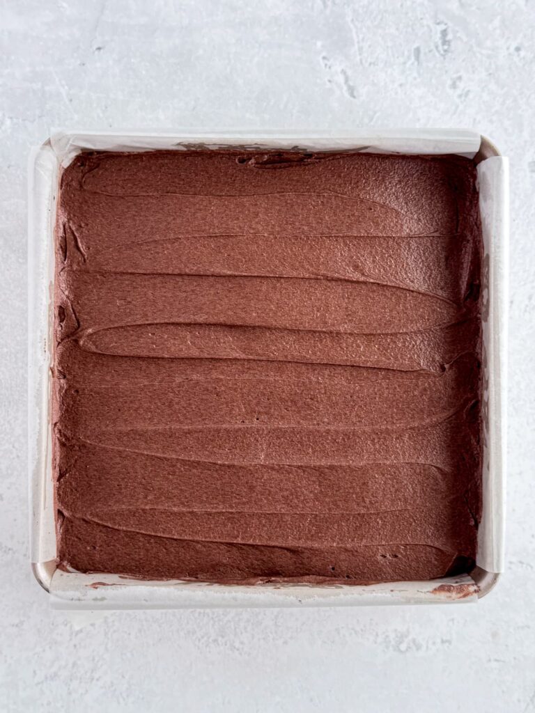 Brownies frosted with chocolate buttercream in a baking pan.