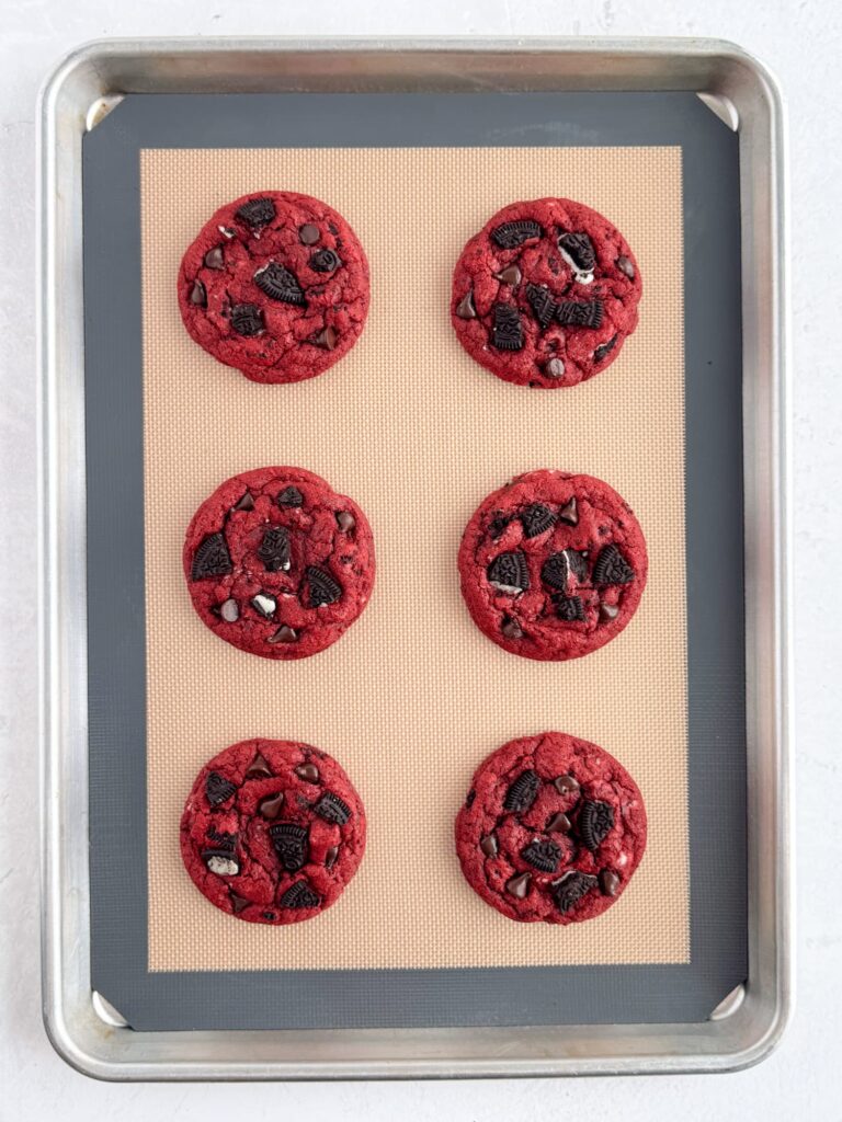 Baked red velvet cookies on a baking sheet pan.