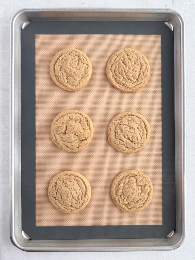 Baked peanut butter cookies on a baking sheet pan.