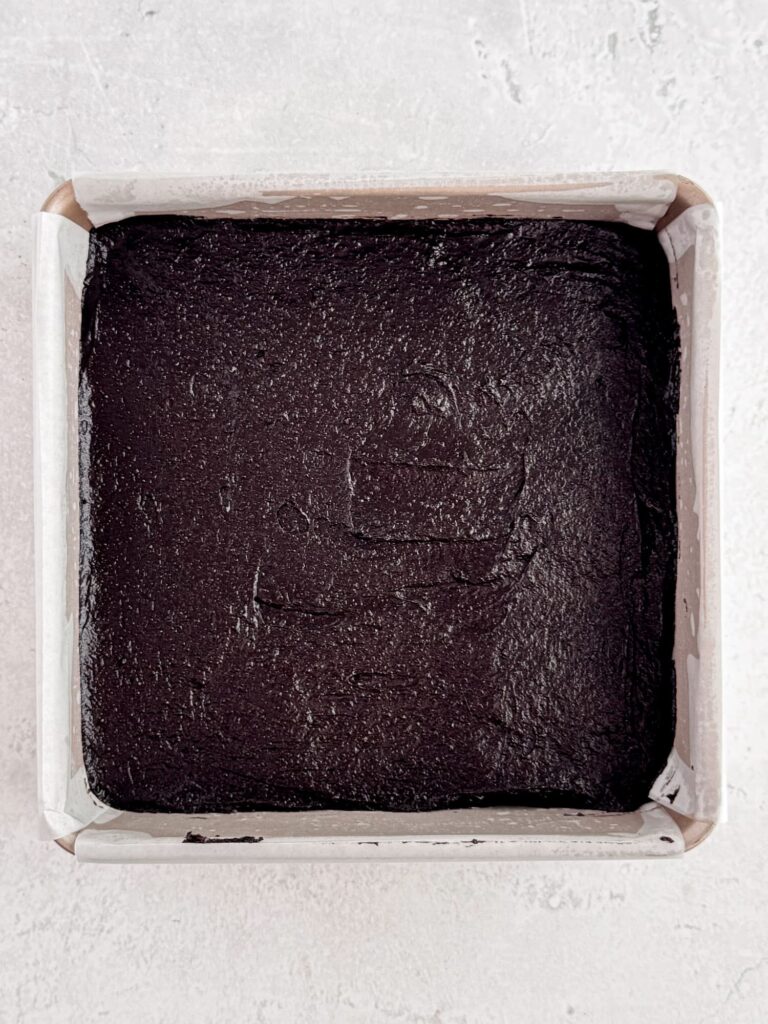 Brownie batter spread into a baking pan.