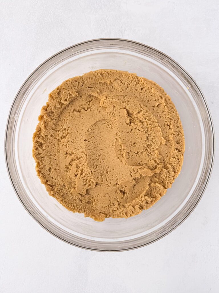 Peanut butter cookie dough in a glass bowl.