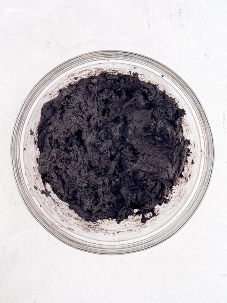 Chocolate cookie dough in a glass mixing bowl.