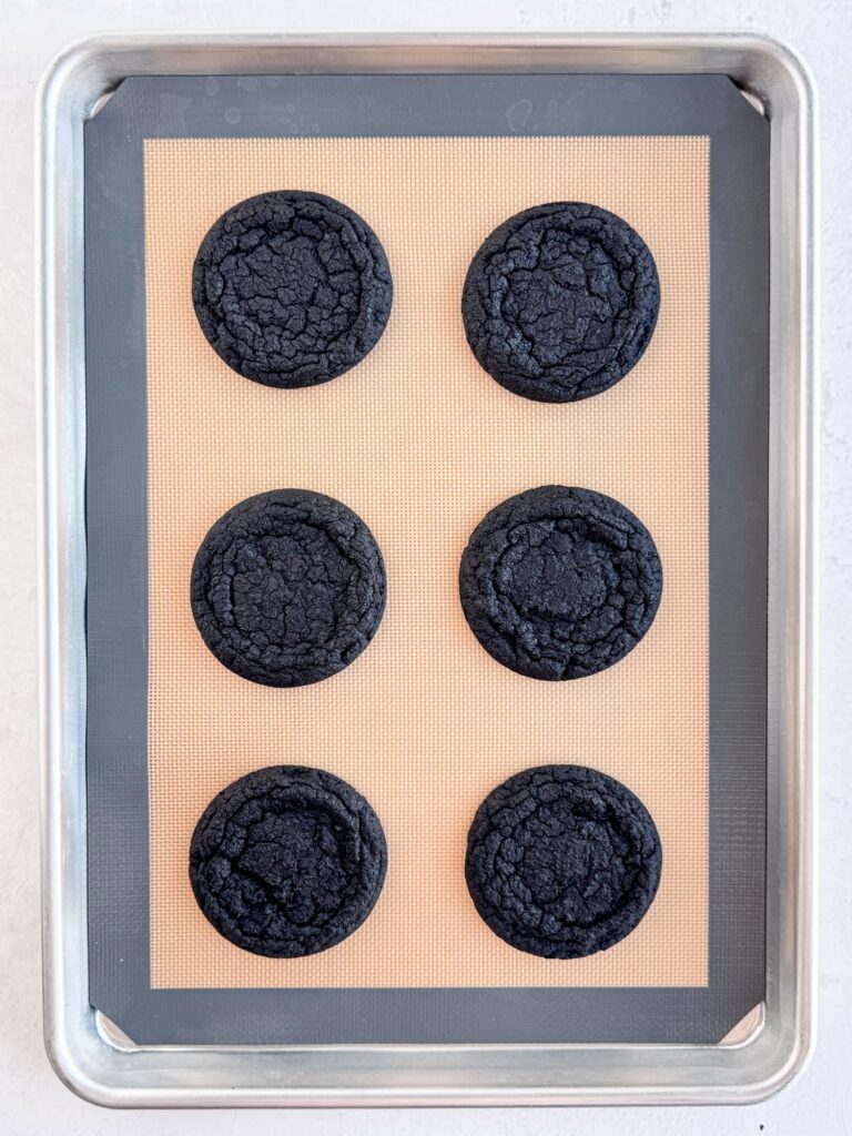 Baked chocolate cookies on a baking pan.