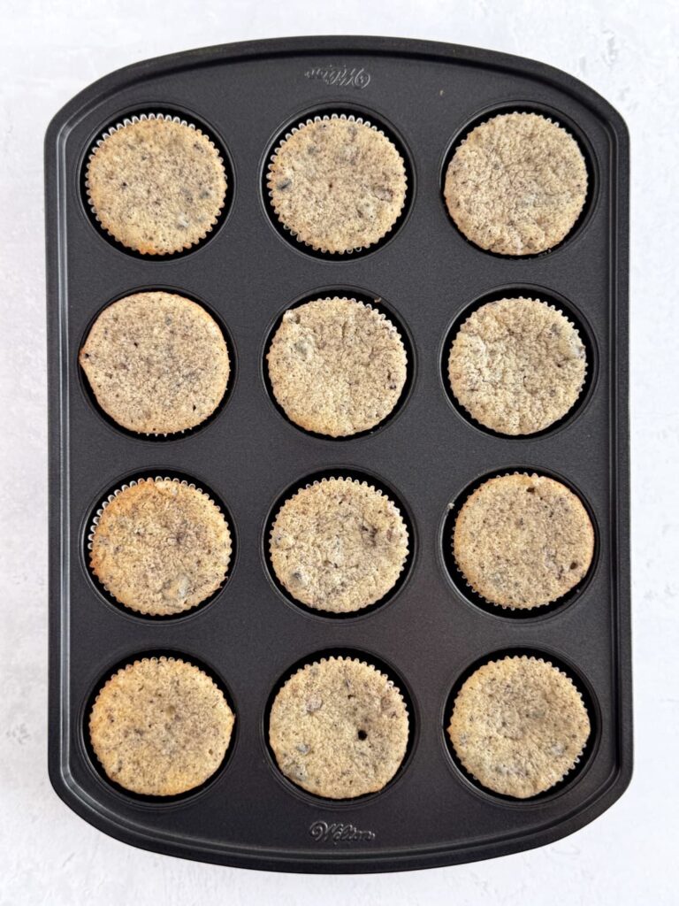 Baked vanilla Oreo cupcakes in a cupcake pan.