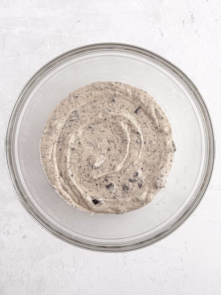 Vanilla cupcake batter with Oreo cookie pieces mixed in.