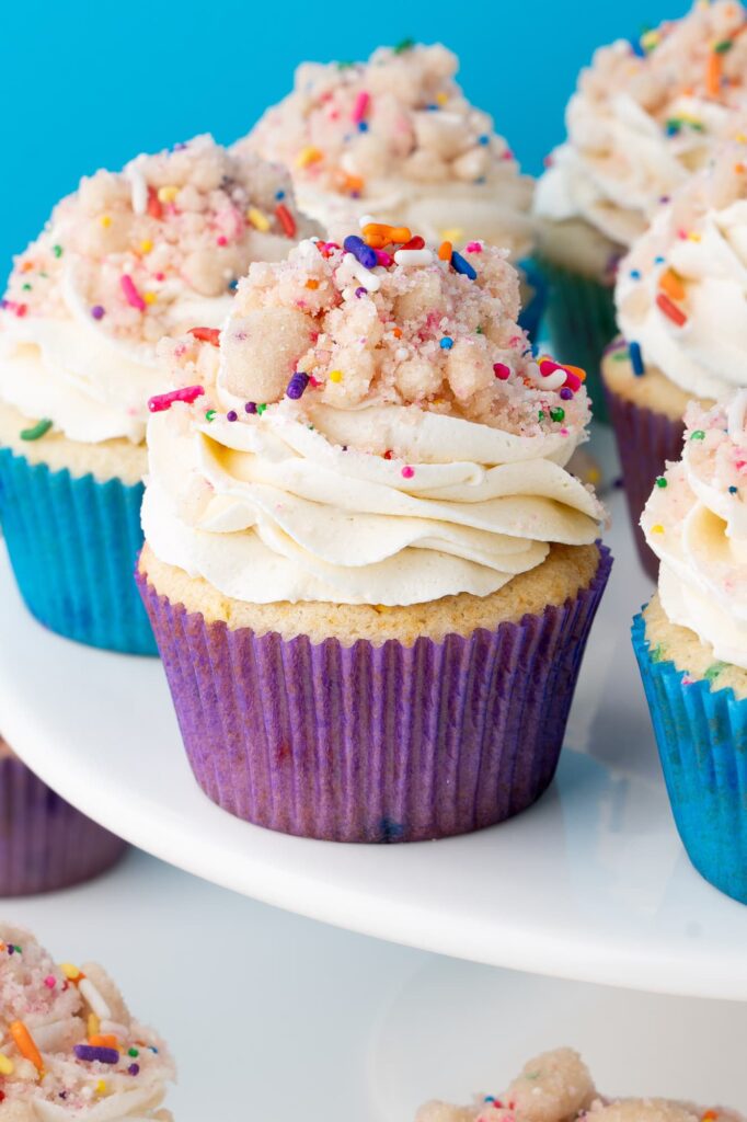 Birthday cake cupcakes on a white cake stand.