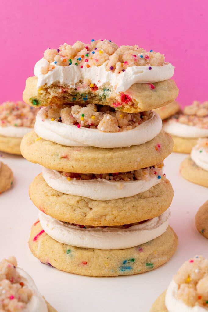 A stack of the frosted birthday cake crumbs with a bite taken out of the top cookie.
