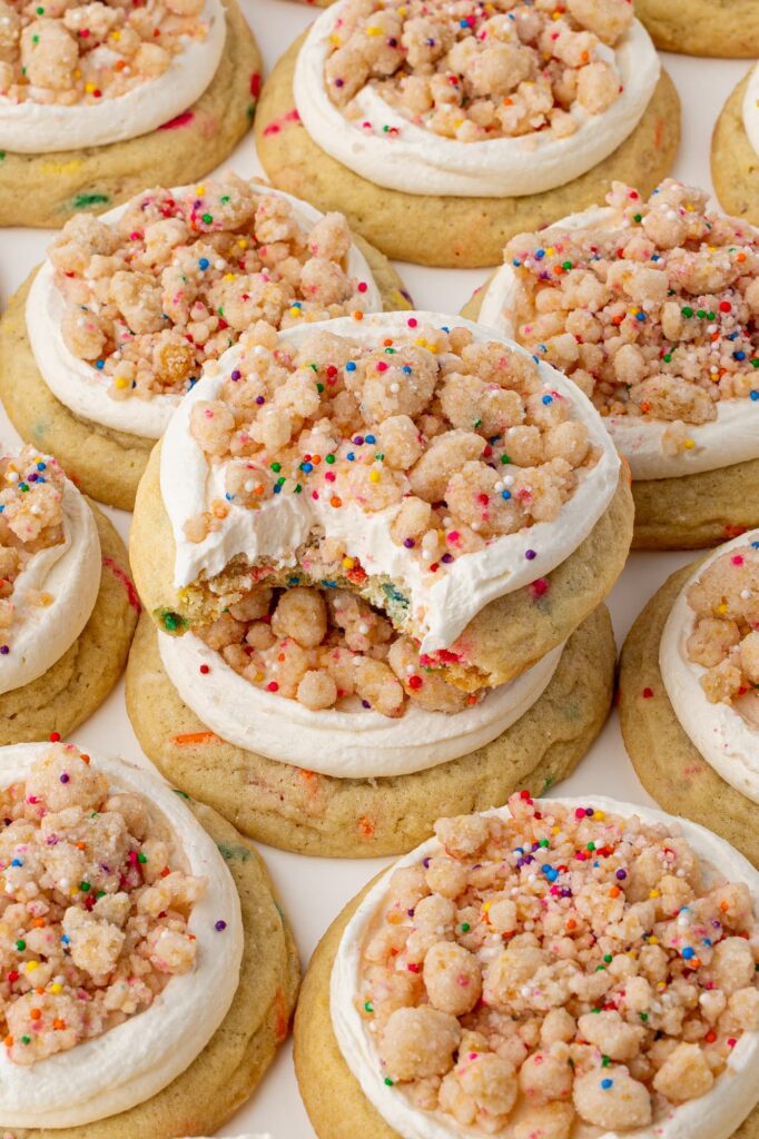 Frosted birthday cake crumbs with a bite taken out of the top cookie.