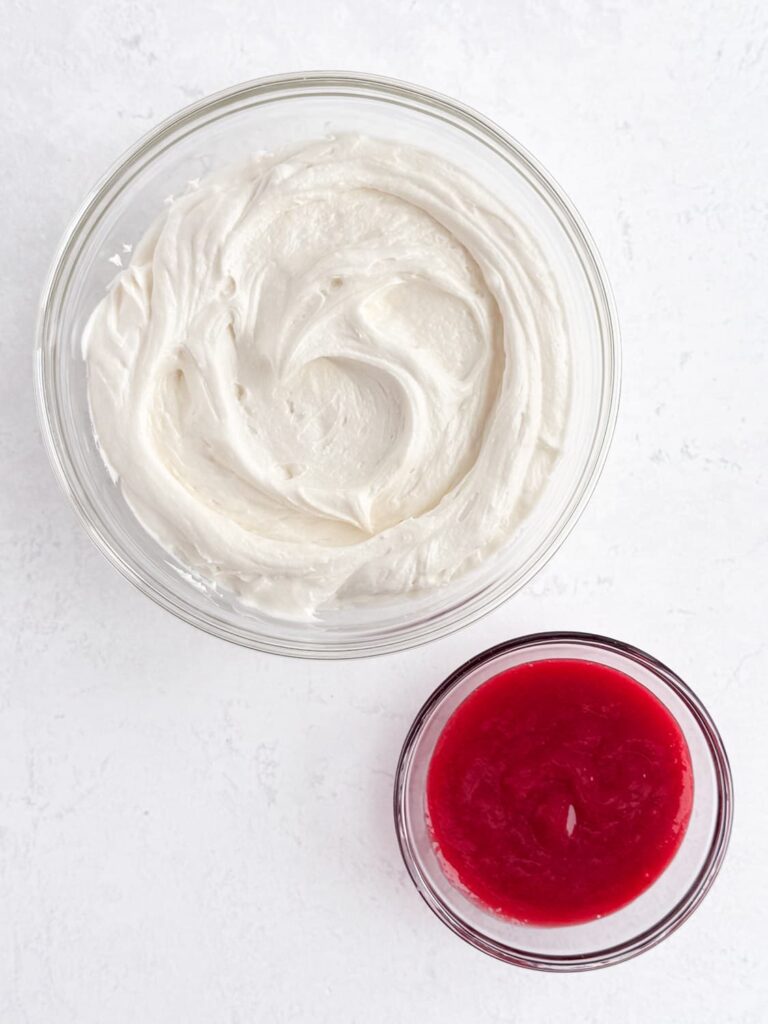 Almond buttercream frosting and raspberry filling in bowls.