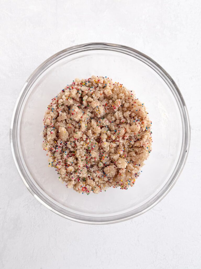 Birthday cake crumbs with the sprinkles added in a mixing bowl.