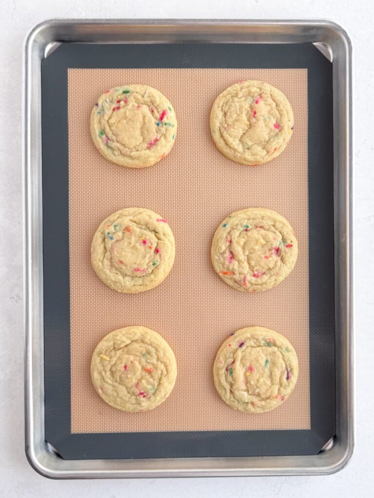 Baked sprinkle cookies on a baking pan.