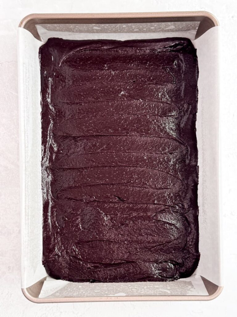 Brownie batter spread in a baking pan.