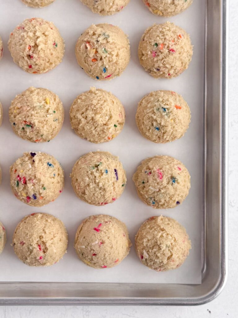 Portioned sugar cookie dough on a baking sheet pan.