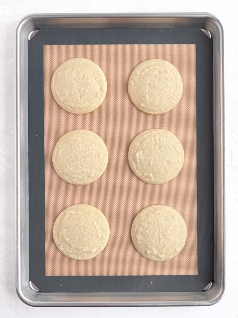 Baked lemon cookies on a baking sheet pan.
