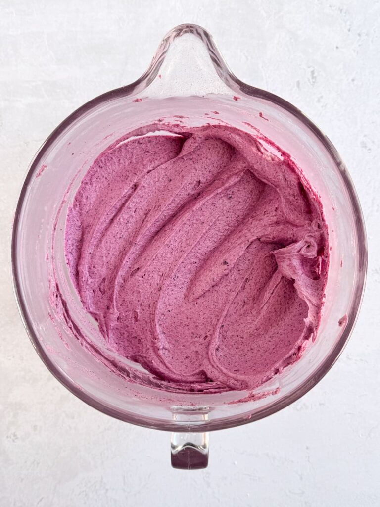 Easy blueberry buttercream frosting in a mixing bowl.