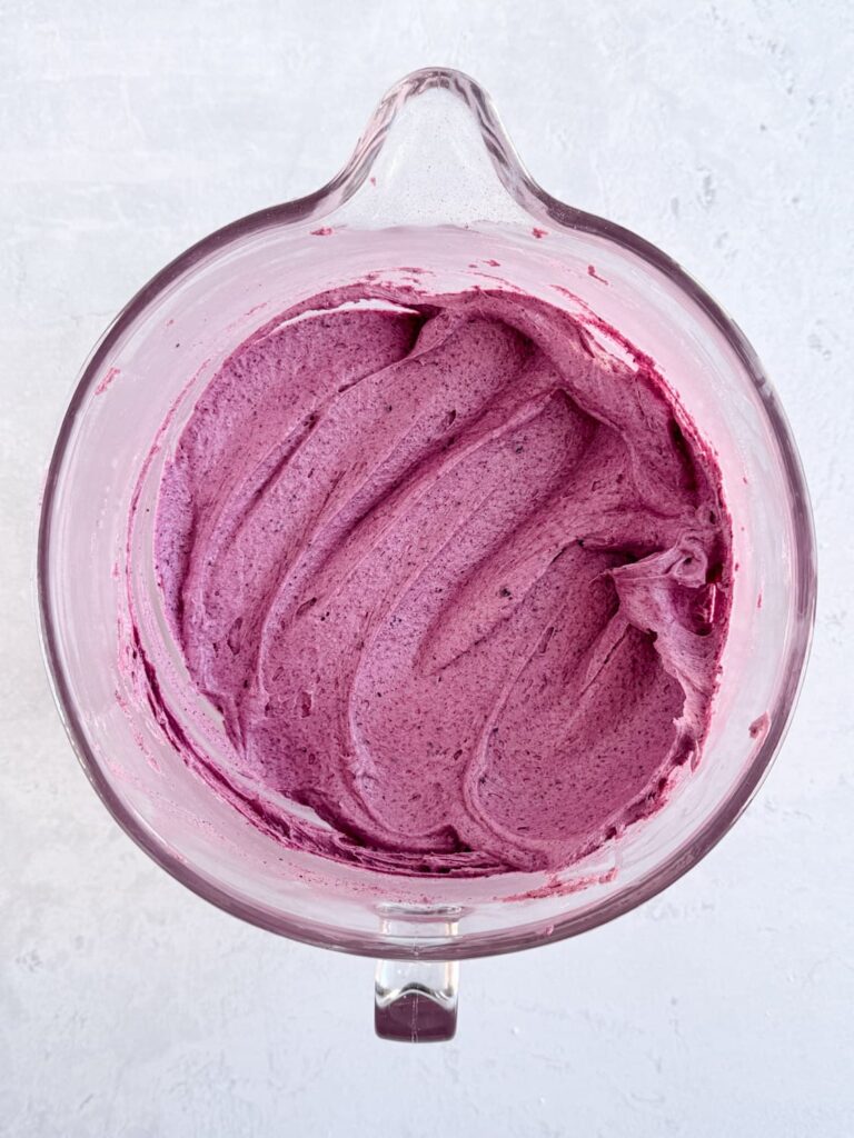 Smooth blueberry buttercream in a mixing bowl.