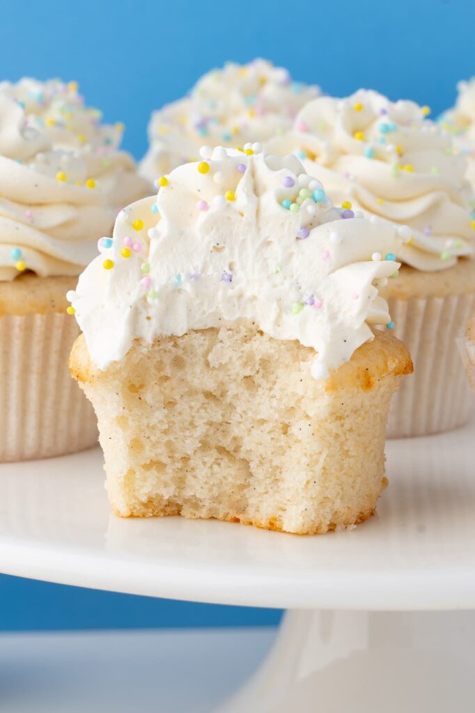 A bite out of a vanilla bean cupcake to show the interior texture.