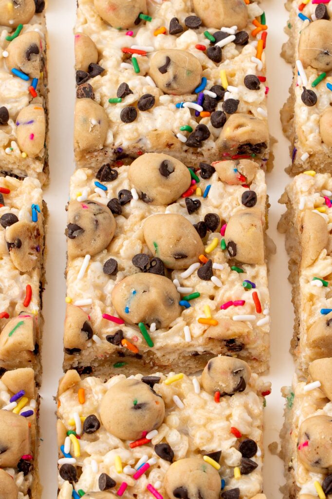 Rice Krispie treats with chocolate chip cookie dough balls and rainbow sprinkles.