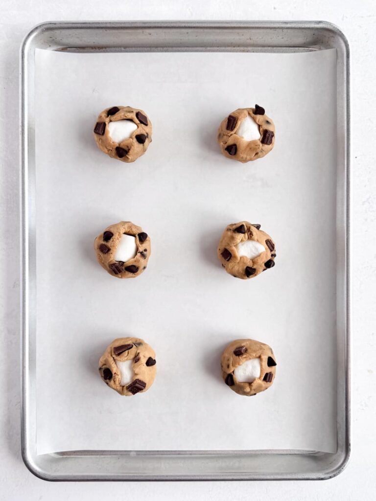 Cookie dough balls on a baking sheet pan.
