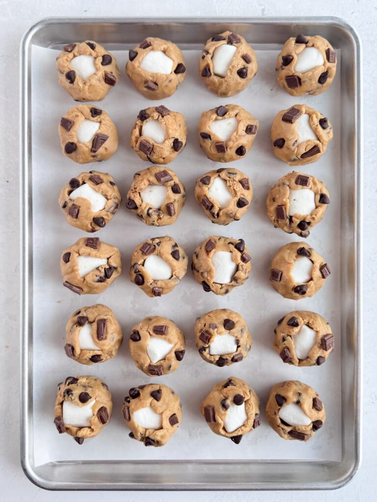 Cookie dough balls on a baking sheet pan.