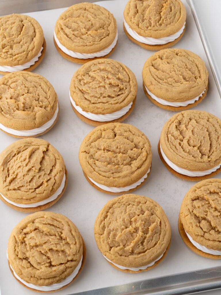 The cookie sandwiches on a baking sheet pan.