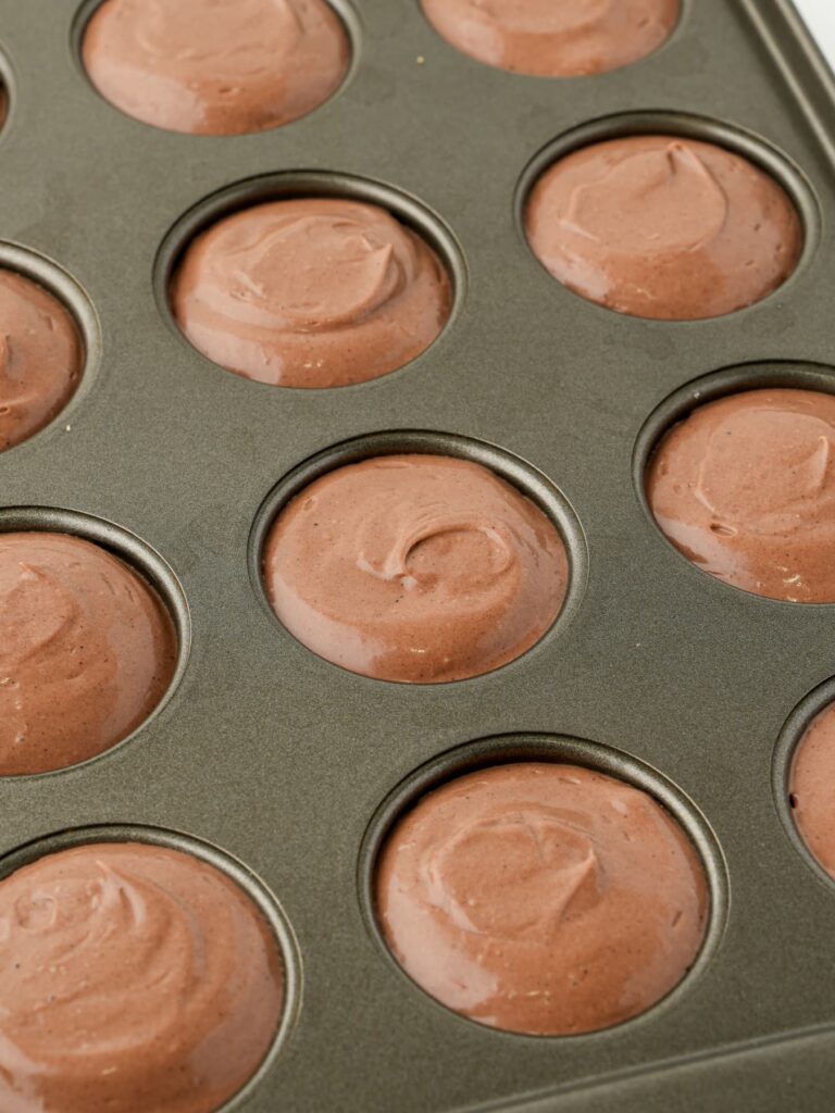 Chocolate cheesecake filling in a mini cheesecake pan.